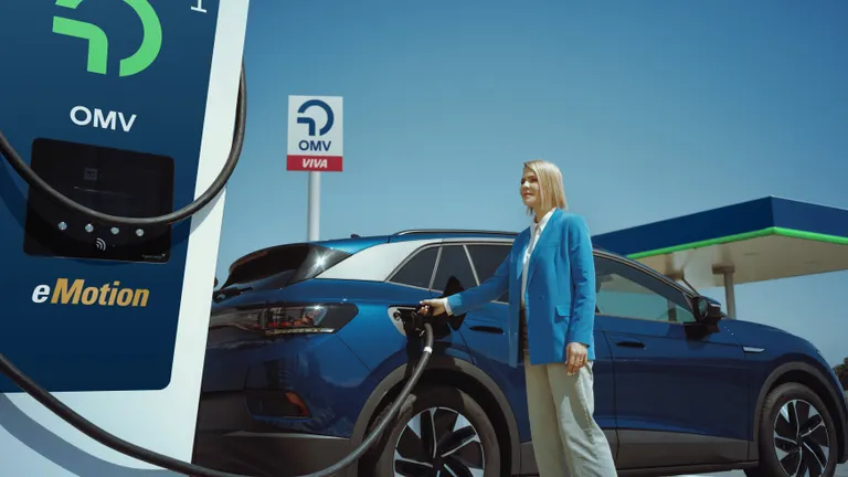 A woman charges her electric car at an OMV station.
