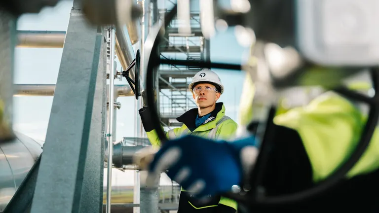 The cover of OMV's Combined Annual Report 2025 features two employees at the OMV Carbon Capture Innovation Center in Auersthal, Austria.